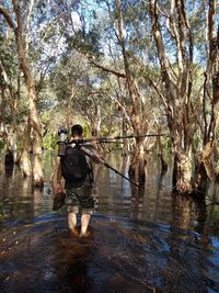 Rear view of man with reflection in lake