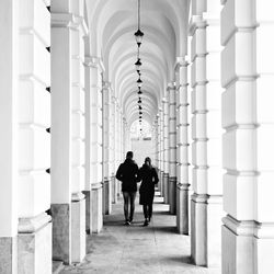 Rear view of people walking in corridor of building