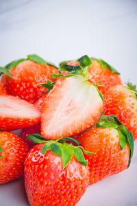 Close-up of chopped strawberries in plate against white background