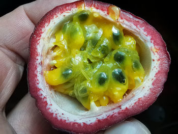 Close-up of hand holding passion fruit