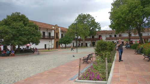 People walking on footpath amidst buildings in city