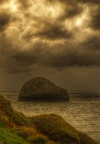 Scenic view of beach against cloudy sky