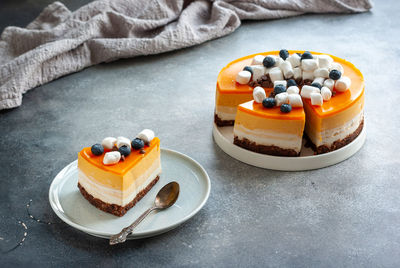 Plate with slice of tasty homemade yellow layered cake on table