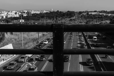 Cars on road by river in city against sky