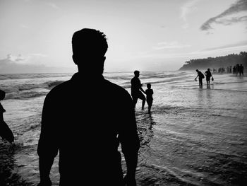 People at beach against sky