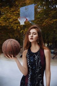Portrait of young woman playing basketball