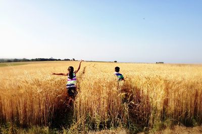 Children running through wheat field