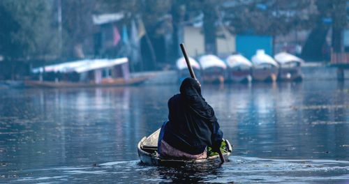 Rear view of man in boat on river