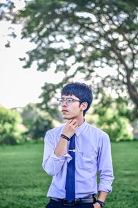 Thoughtful young man standing at park