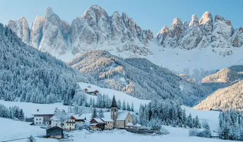 The small village val di funes covered in snow, with dolomites mountains, south tyrol, italy.