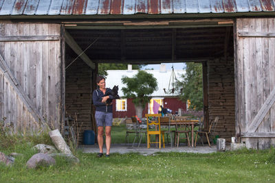 Woman with cat in front of barn