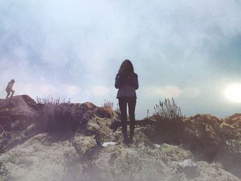 Woman standing on mountain against sky