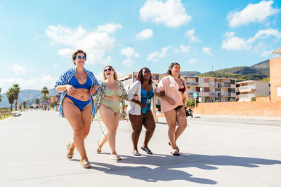 Rear view of friends standing at beach