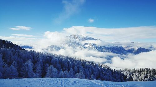 Scenic view of snow covered mountains against blue sky