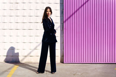 Portrait of woman standing against wall