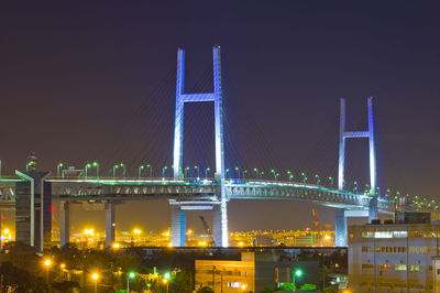 Illuminated bridge and buildings at night