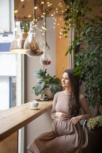 Pregnant woman sitting on chair in cafe