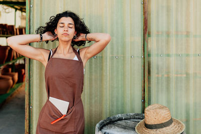 Portrait of woman standing against wall