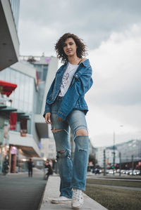 Portrait of smiling young woman standing on footpath