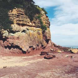 Scenic view of beach against cloudy sky