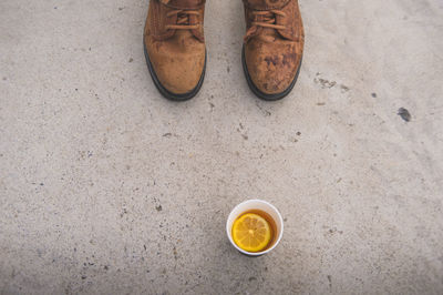 Close-up high angle view of boots and tea on ground