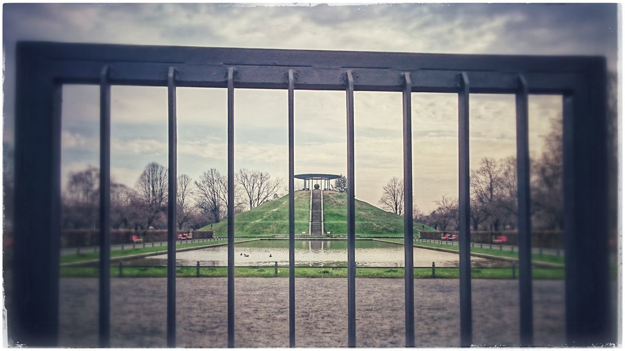 sky, grass, cloud - sky, fence, cloudy, built structure, architecture, cloud, transfer print, green color, railing, field, day, grassy, nature, protection, tree, auto post production filter, lawn, building exterior