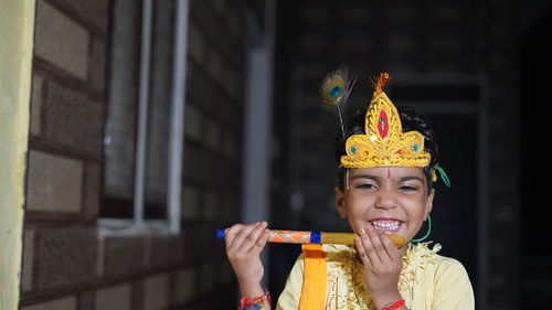 Indian little child wearing lord krishna costume with flute or bansuri and celebration 