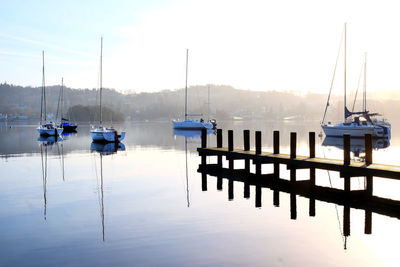 Boats moored in lake against sky