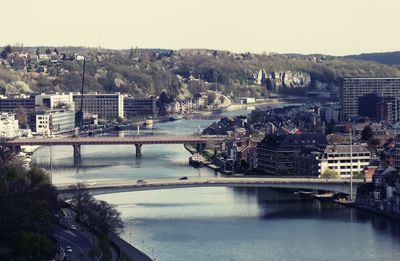 Bridge over river in city against sky