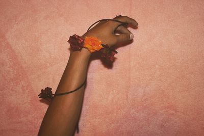 Close-up of woman hand holding flower bouquet against gray background