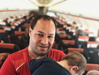 Portrait of father standing with son in airplane