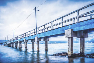 Low angle view of bridge over sea against sky