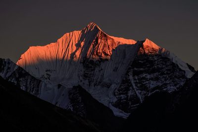 Low angle view of snow mountain against sky at sunset
