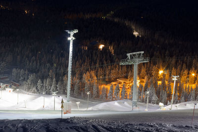 Illuminated street lights on snow covered land