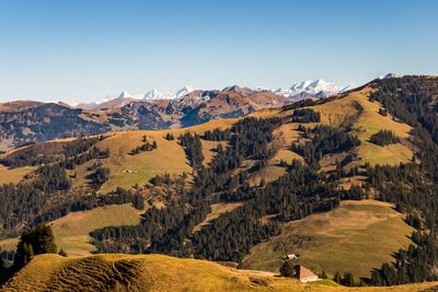 Scenic view of landscape and mountains against clear sky