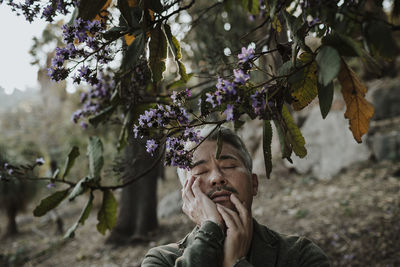 Portrait of man against purple flowering plants