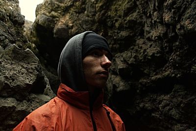 Close-up of thoughtful man wearing warm clothing against rocks