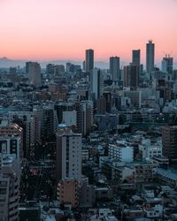 Aerial view of buildings in city against sky during sunset