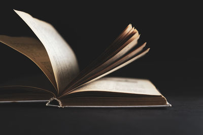 Close-up of open book against black background