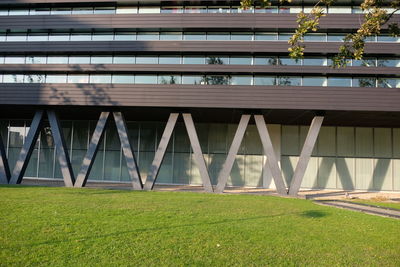 Low angle view of bridge on field against modern building