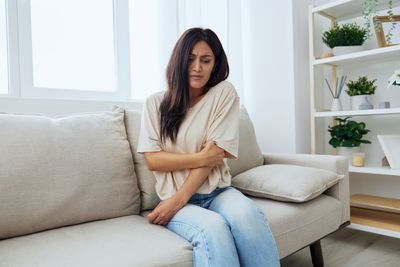 Portrait of young woman sitting on sofa at home