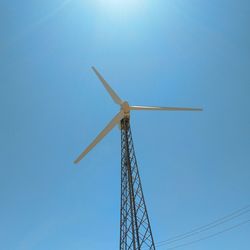 Low angle view of windmill against clear blue sky