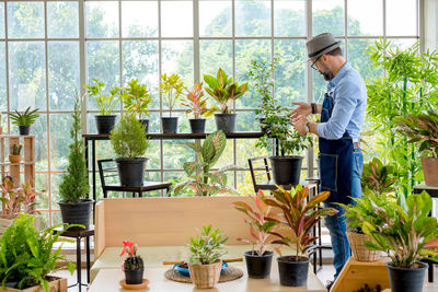 Man standing by potted plants on table