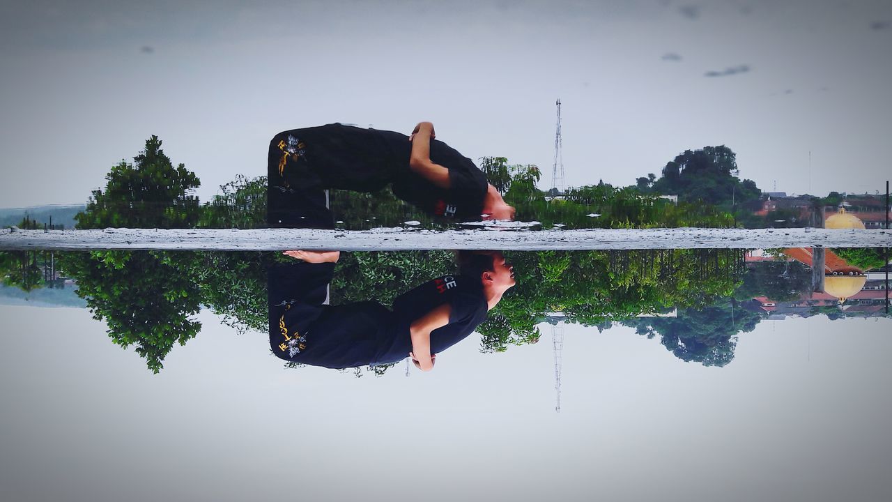 MAN SITTING ON WOMAN LOOKING AT LAKE