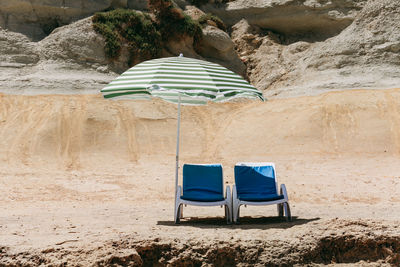 Deck chairs under parasol at beach