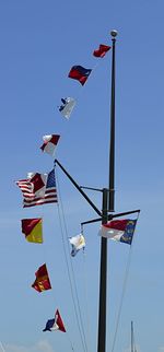 Low angle view of flags against clear sky