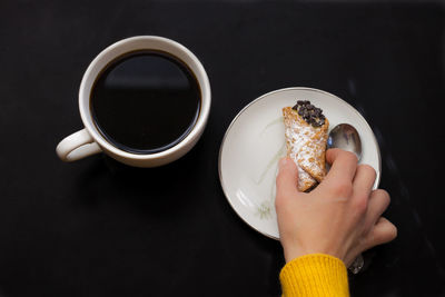 Close-up of hand holding coffee cup