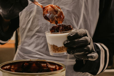 Midsection of man holding drink on table