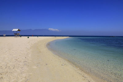 Scenic view of beach against clear blue sky