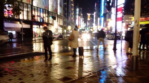 Illuminated city street during rainy season at night